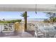 Breezy porch view of the beach and ocean with a dining set at 12458 1St W St, Treasure Island, FL 33706