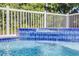 Close-up of spa with soothing water cascading over blue, patterned tile at 12458 1St W St, Treasure Island, FL 33706