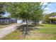 This home features a partially fenced front yard with mature trees at 12660 118Th St, Largo, FL 33778