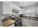 Bright kitchen with white cabinets, granite countertops, and stainless steel appliances at 12660 118Th St, Largo, FL 33778
