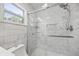 Modern shower with glass doors, tiled walls, and built-in shelving for organization at 12660 118Th St, Largo, FL 33778