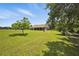 Expansive backyard with lush green grass and mature trees offers plenty of room for outdoor activities at 13122 Done Groven Dr, Dover, FL 33527