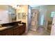 Bathroom featuring double vanity, granite counters, tiled floors, and a glass-enclosed shower at 13122 Done Groven Dr, Dover, FL 33527