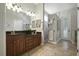Bright bathroom with double vanity, granite counters, tiled floors, and a glass-enclosed shower, providing a spa-like experience at 13122 Done Groven Dr, Dover, FL 33527
