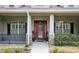 Charming home featuring a vibrant red front door, decorative stone accents, and meticulous landscaping at 13122 Done Groven Dr, Dover, FL 33527