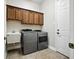 Functional laundry room with washer, dryer, utility sink, and ample cabinet space for storage at 13122 Done Groven Dr, Dover, FL 33527