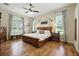 Cozy main bedroom featuring hardwood floors, large windows, and stylish decor for a peaceful retreat at 13122 Done Groven Dr, Dover, FL 33527