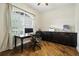 Well-lit home office with hardwood floors, custom cabinets, and a large window for a comfortable workspace at 13122 Done Groven Dr, Dover, FL 33527