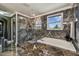 Modern bathroom with glass shower, soaking tub, and window offering natural light and a view at 1314 Oak Pond St, Ruskin, FL 33570