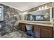 Elegant bathroom featuring marble tiling, granite countertops, and a large vanity mirror for a luxurious feel at 1314 Oak Pond St, Ruskin, FL 33570