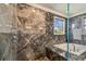 Shower and tub clad in marble tiling offer a spa-like experience in this tranquil bathroom at 1314 Oak Pond St, Ruskin, FL 33570