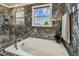 Bright bathroom showcases a luxurious soaking tub with marble surround, paired with sleek fixtures and a window at 1314 Oak Pond St, Ruskin, FL 33570