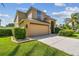 Beautiful stucco home featuring a two-car garage and mature landscaping at 1314 Oak Pond St, Ruskin, FL 33570