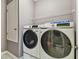 Laundry room features a modern washer and dryer set, plus shelving for storage at 1314 Oak Pond St, Ruskin, FL 33570