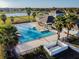 Aerial view of a community pool and recreation center with palm trees and lounge chairs in a neighborhood at 1314 Oak Pond St, Ruskin, FL 33570