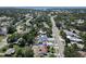 High aerial shot with a blue border showing the house, driveway, and nearby roads at 1410 Nebraska Ave, Palm Harbor, FL 34683