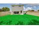 Large backyard with lush lawn, patio furniture, and fenced yard provides a private outdoor retreat at 1410 Nebraska Ave, Palm Harbor, FL 34683