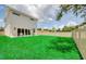 Spacious lawn with seating area outside sliding glass doors and a full wooden privacy fence at 1410 Nebraska Ave, Palm Harbor, FL 34683