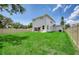 Expansive backyard with lush green lawn, modern white home with sliding doors to patio at 1410 Nebraska Ave, Palm Harbor, FL 34683