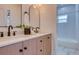 Bathroom featuring dual sinks, arched mirrors, cabinet storage, and modern fixtures at 1410 Nebraska Ave, Palm Harbor, FL 34683