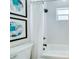 Bathroom with a tub, shower, and decorative art pieces on the wall above the toilet at 1410 Nebraska Ave, Palm Harbor, FL 34683