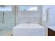 Modern bathroom featuring marble accents, shower, bathtub, and sleek fixtures at 1410 Nebraska Ave, Palm Harbor, FL 34683