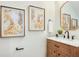 Elegant powder room featuring a marble countertop, wood cabinet, and gold-framed artwork for a touch of sophistication at 1410 Nebraska Ave, Palm Harbor, FL 34683