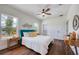 Bright bedroom with a wood-toned ceiling fan and a comfortable bed with a blue headboard at 1410 Nebraska Ave, Palm Harbor, FL 34683