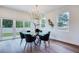 Modern dining area with contemporary lighting, hardwood floors, and large windows at 1410 Nebraska Ave, Palm Harbor, FL 34683