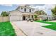 Charming two-story home with a manicured lawn and cozy outdoor seating area in front at 1410 Nebraska Ave, Palm Harbor, FL 34683