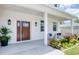 Inviting front porch featuring a stylish front door, decorative plants, and comfortable seating at 1410 Nebraska Ave, Palm Harbor, FL 34683