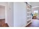 Hallway featuring a modern glass barn door that opens into a room with natural light and a view at 1410 Nebraska Ave, Palm Harbor, FL 34683