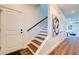 Bright hallway with wood floors, a staircase, and neutral decor leading to the home's living spaces at 1410 Nebraska Ave, Palm Harbor, FL 34683