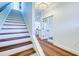 Staircase leading to a bright hallway, featuring hardwood floors and stylish lighting fixtures at 1410 Nebraska Ave, Palm Harbor, FL 34683
