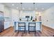 Bright kitchen with marble island, bar stool seating, stainless steel appliances, white cabinets, and modern pendant lights at 1410 Nebraska Ave, Palm Harbor, FL 34683