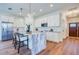 Open kitchen with a marble island, seating, stainless steel appliances, white cabinets, and stylish pendant lighting at 1410 Nebraska Ave, Palm Harbor, FL 34683