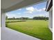 Spacious backyard views from under covered patio, with lush green grass and clear blue skies at 14279 Swiss Bridge Dr, Riverview, FL 33579