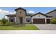 Beautiful single-story home with stone accents, a tile roof, three-car garage, and manicured landscaping at 14279 Swiss Bridge Dr, Riverview, FL 33579