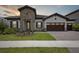 Charming home featuring stone accents, a tile roof, manicured lawn, and a paver driveway at 14279 Swiss Bridge Dr, Riverview, FL 33579