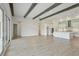 Expansive living area features wood beams, light wood flooring, and seamless flow to kitchen at 14279 Swiss Bridge Dr, Riverview, FL 33579
