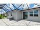 Backyard featuring a screened-in lanai with a stone paver patio and view of the pond, slider, and windows at 14424 59Th E Cir, Bradenton, FL 34211
