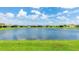 Backyard view featuring a large pond and neighborhood houses, with lush green grass in the foreground at 14424 59Th E Cir, Bradenton, FL 34211