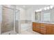 Modern bathroom featuring a glass-enclosed shower, soaking tub, double vanity, and sleek fixtures for a luxurious feel at 14424 59Th E Cir, Bradenton, FL 34211