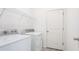 Bright laundry room featuring modern washer and dryer, and ample storage with white wire shelving and neutral colored door at 14424 59Th E Cir, Bradenton, FL 34211