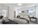 Serene main bedroom featuring neutral colors, plush bedding, bedside tables, and ample natural light from large windows at 14424 59Th E Cir, Bradenton, FL 34211