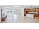 Open-concept living and kitchen area with wood cabinets, granite counters, and wood-look floors at 14424 59Th E Cir, Bradenton, FL 34211