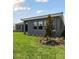 Exterior side view of the grey home with an irrigation system planted around the house at 14523 Swiss Bridge Dr, Lithia, FL 33547