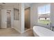 Bright bathroom with soaking tub, tiled floors, walk-in shower, and walk-in closet at 14523 Swiss Bridge Dr, Lithia, FL 33547