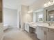 Bright bathroom with double vanity, tiled floors, soaking tub, shower, and views to the outside at 14523 Swiss Bridge Dr, Lithia, FL 33547