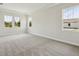Bright, carpeted bedroom with three windows showing natural light and neutral paint to accommodate any style at 14523 Swiss Bridge Dr, Lithia, FL 33547